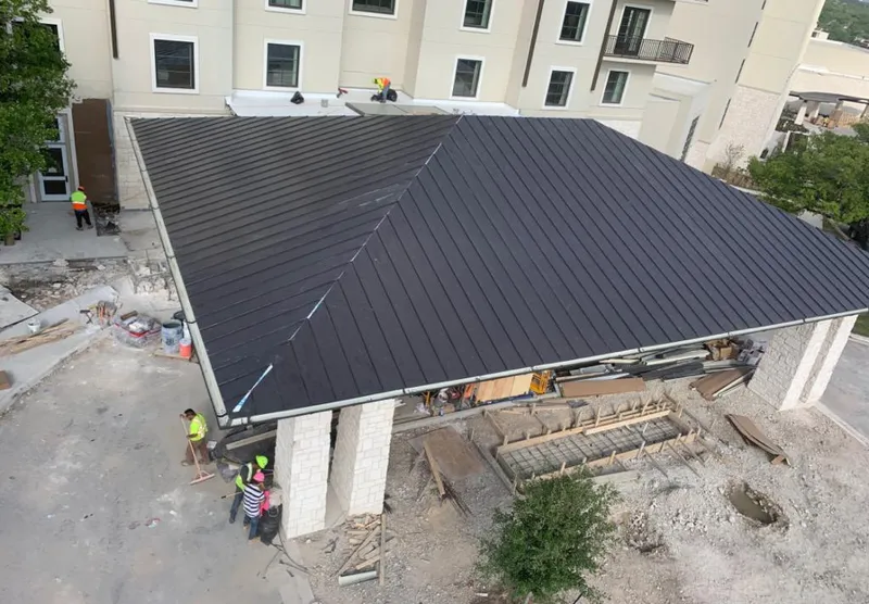 Metal roofing installation team working on a commercial building in Benton